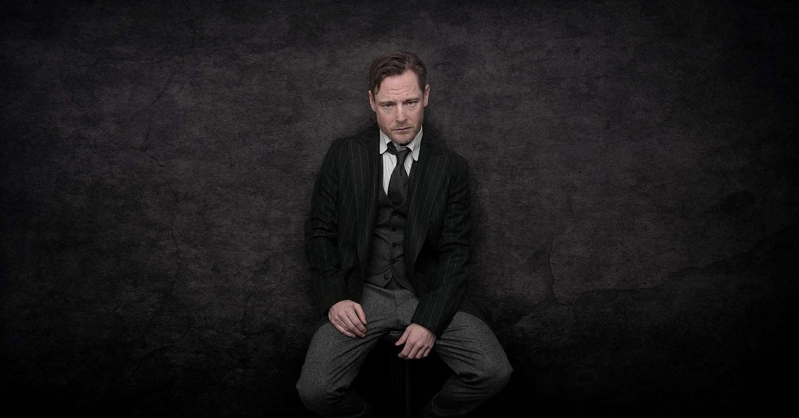 Paw Henriksen sidder på en stol i tøj inspireret af 1920´erne i England - Portrætfotograf www.christiankrog.dk