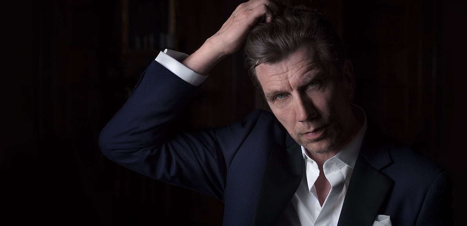 Jesper Lohmann, tager sig til hået, sidder på The Library Bar i københavn - Fotograf Christian Krog - Portrætfotograf