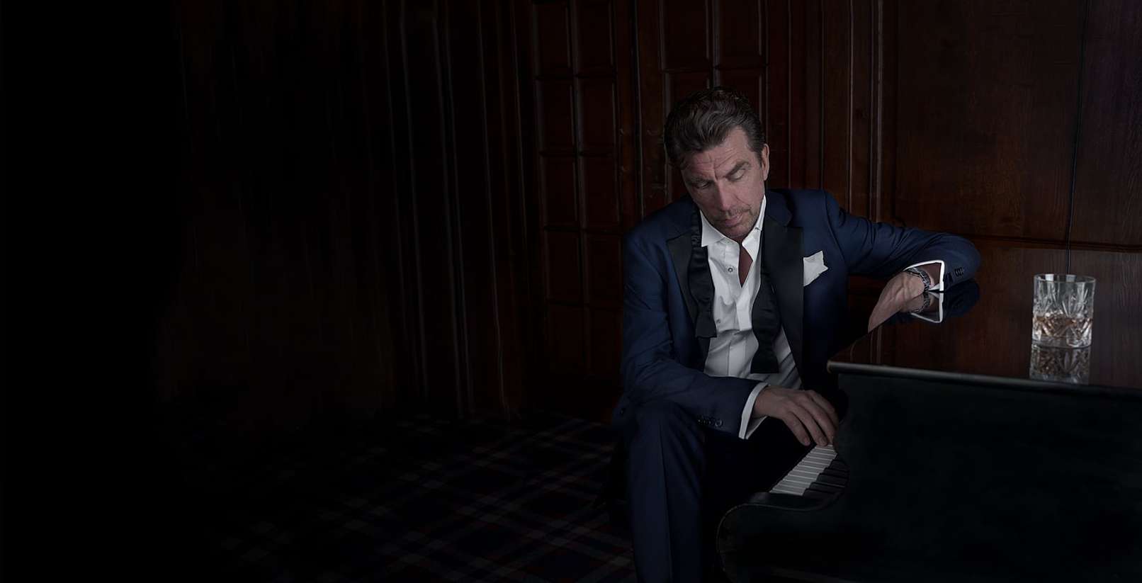 Jesper Lohmann,sidder ved et piano, på The Library Bar i københavn - Fotograf Christian Krog - Portrætfotograf