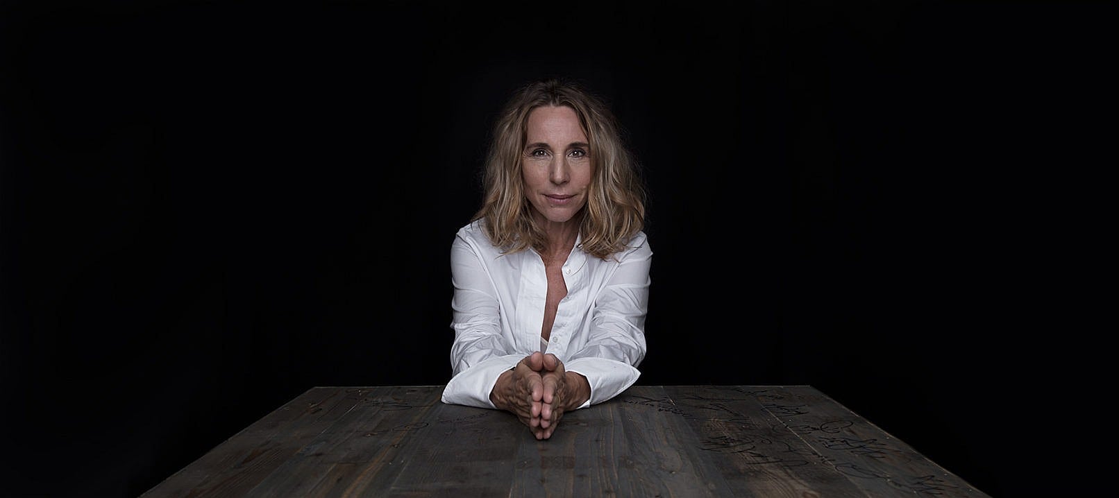 Ann-Eleonora Jørgensen, sidder ved et bord med foldede hænder - Fotograf Christian Krog - Portrætfotograf