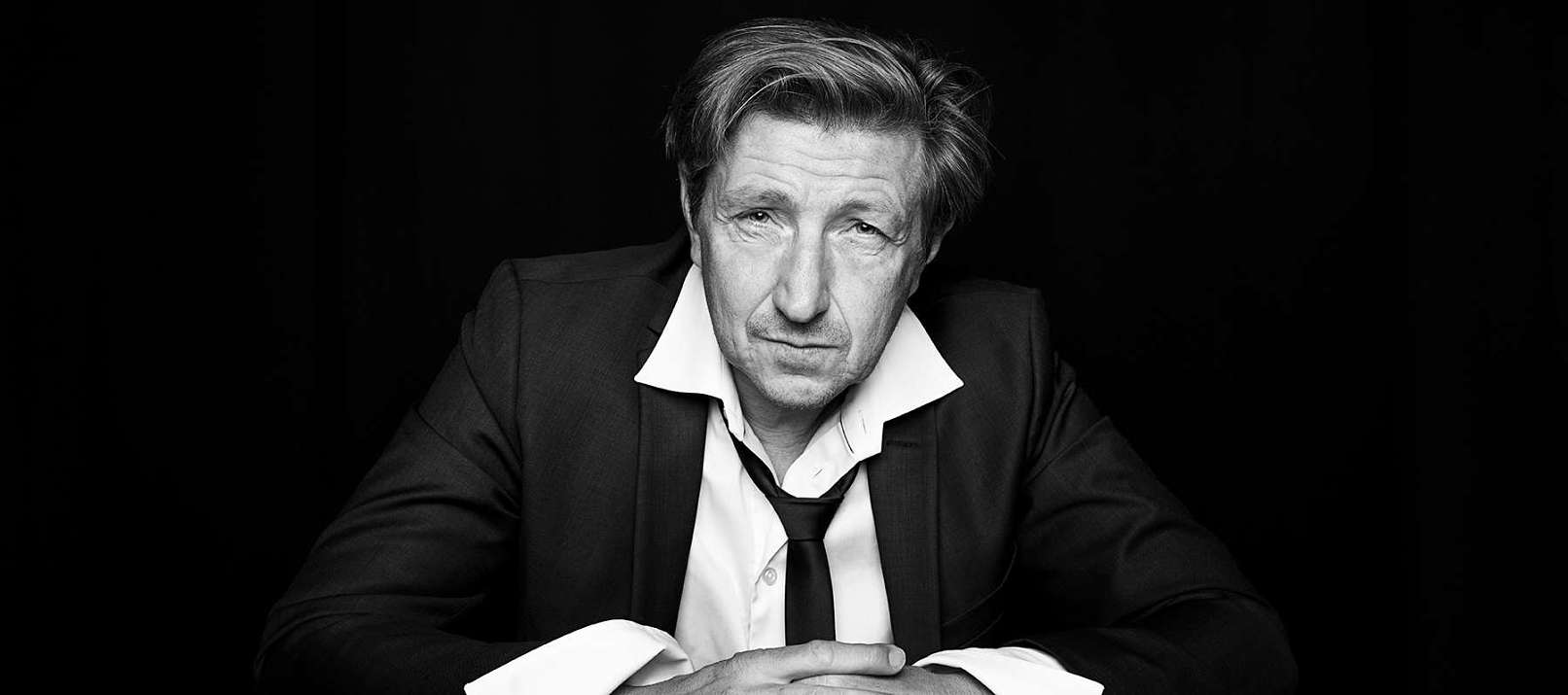 Nicolaj sidder ved et bord, og ser lidt opgivende ud. Billedet er taget af Christian Krog. Portrætfotograf. Nicolaj Kopernikus. Forbrydelsen. Klassefesten